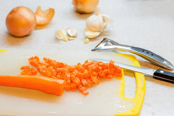 Cooking vegetarian soup of chickpeas and broccoli. knife, carrot,  onion and potato on a board