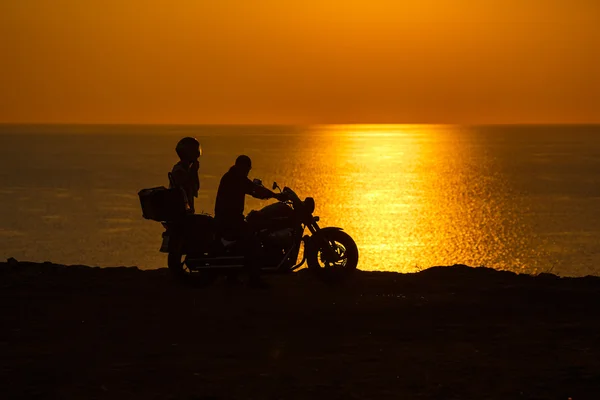 Two people in the motorcycle at sunset on the Black Sea