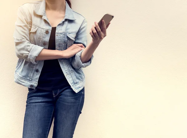 Woman in jeans fashion holding mobile phone