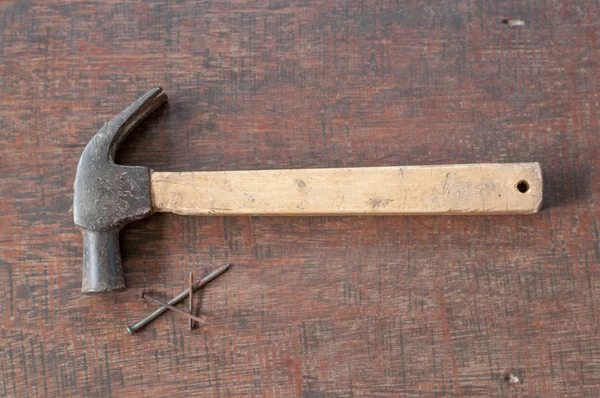 Old rust hammer and nails on wood board