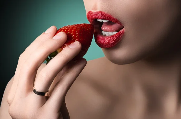 Sexy lips with strawberry. White teeth and skin. Green backgroun