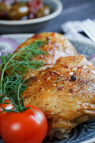 Roasted chicken and vegetables on dark wooden background