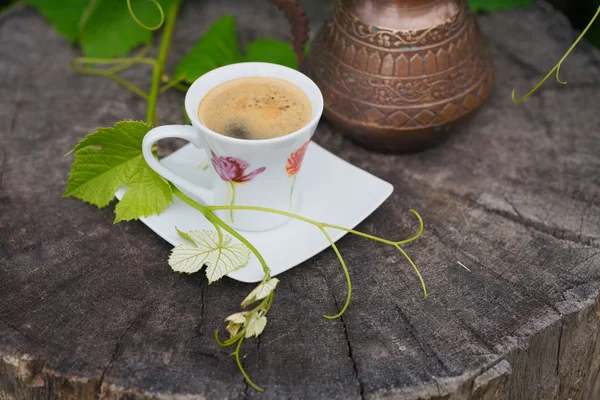 Still life with antique pitcher and cup of coffee covered with g