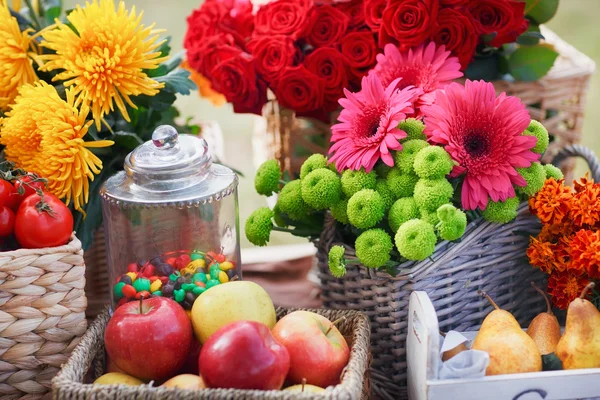 Autumn flowers in a basket, apples and pears as table decoration