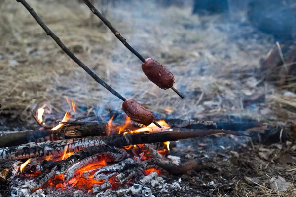Sausages on the stick grilled in the fire