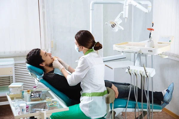 Female dentist with male patient at dental office. Concept of healthy