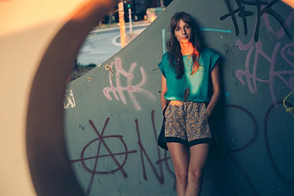 Girl leaning on graffiti wall