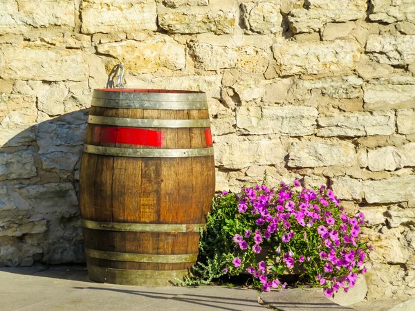 Old wooden barrel and flowers. Street still life