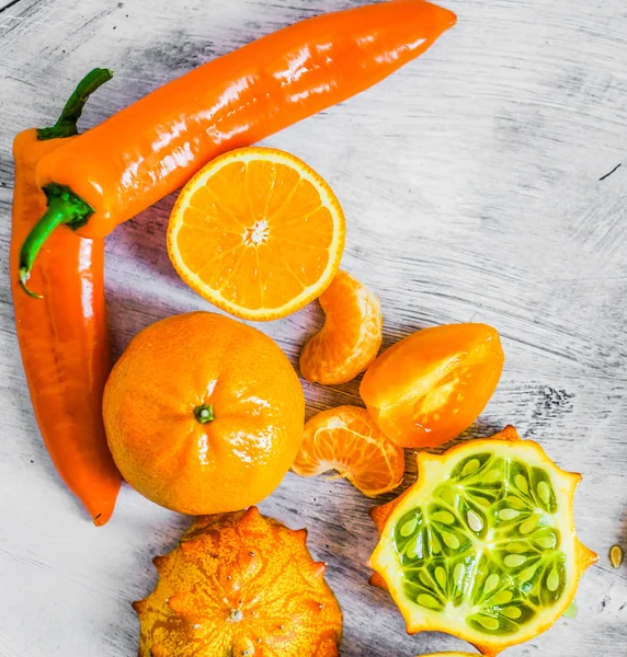 Orange fruits and vegetables on rustic background