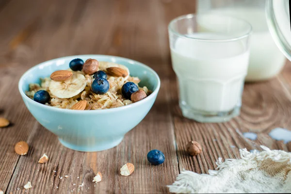 Oatmeal porridge breakfast with nuts, berries and milk