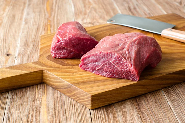 Fresh raw meat on chopping board. two peece of beef