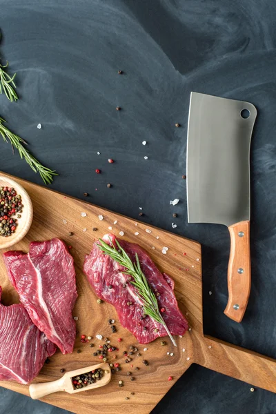 Fresh raw meat on chopping board with knife. top-view