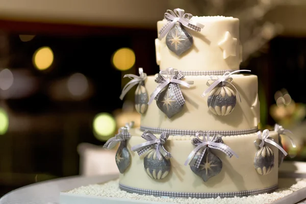 White decorated cake with three layers and ribbons