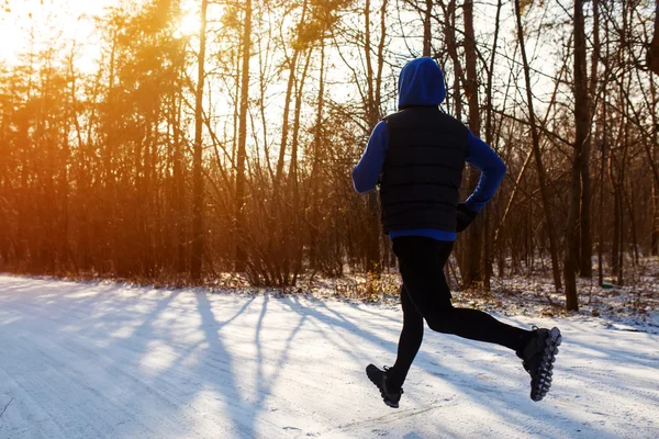 Winter Running. Young, athletic man running in the park. Sport Lifestyle. Morning. Sport, winter clothes