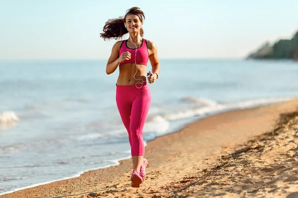 Fitness runner woman running on beach
