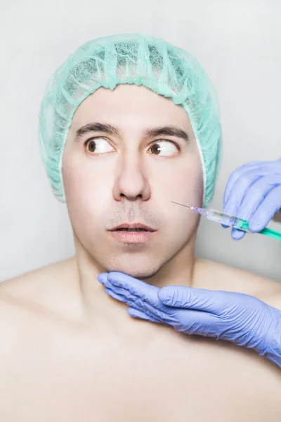 Doctor aesthetician makes face beauty injections to male patient