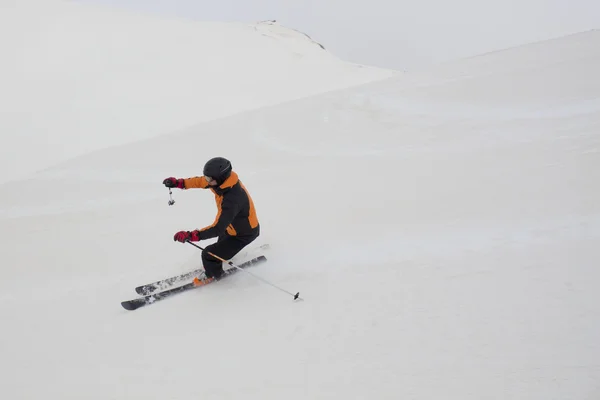 Skier hoping tails while skiing in a ski slope