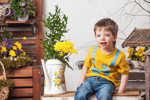Children on the background of spring decor in yellow T-shirts , flower meadow .