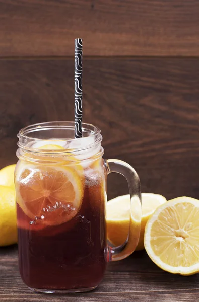 Elderberry lemonade. Mason jar of elderberry juice and lemon on a wooden background, healthy nutrition, alternative medicine and therapy