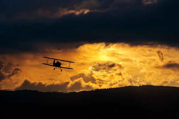Biplane in evening sky