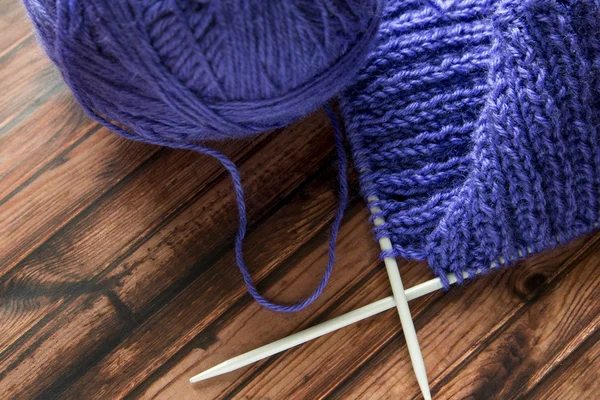 Lilac yarn and knitted product on the table