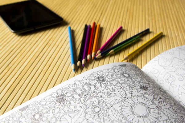 Relaxing coloring book with flowers and leaves and pencils. The
