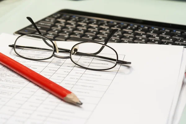 Not staged work with documents at home. Documents, pencil, glasses, keyboard