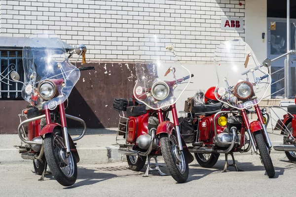 Three JAVA motorcycle retro stand against the wall./xhibition of old Soviet motorcycle JAVA outdoors during the holiday of the day the city of Cheboksary.