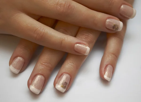 Beautiful woman\'s nails with french manicure on the white backgr