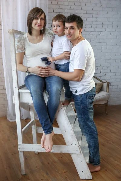 Pregnant women with her husband and son at the ladder