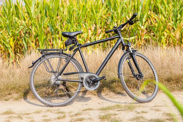 One black bike on a corn field