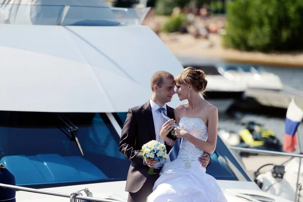 Wedding couple hugging on yacht