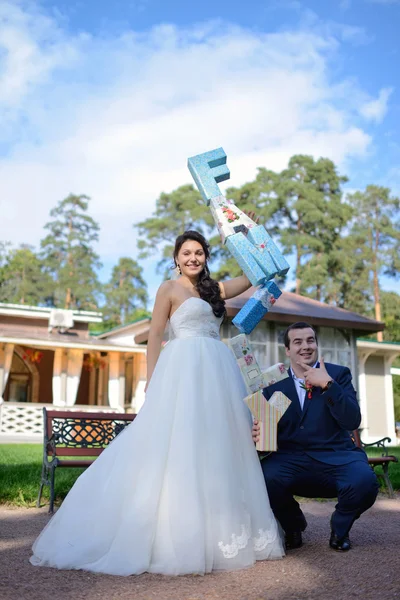 Beautiful wedding couple holding letters