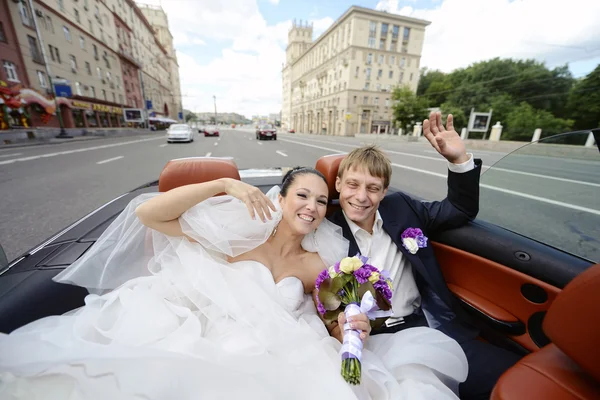 Wedding couple hugging in car