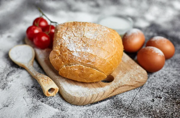 Ingredients for the preparation of bakery products. Bread, flour, eggs and cherry tomatoes.