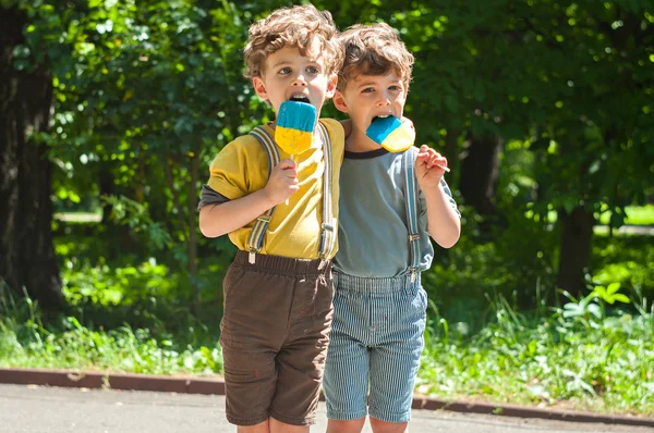 Identical twins with lollipops