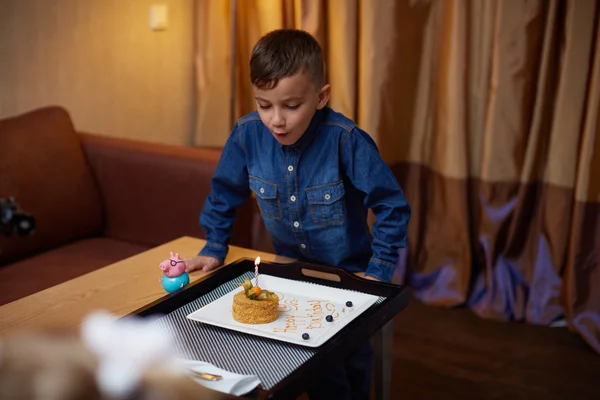 Birthday boy blowing out the candles on his cake.