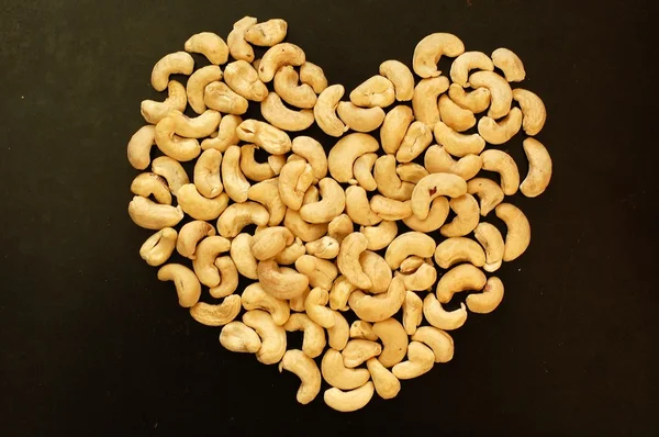 Heart from cashew nuts on the black background