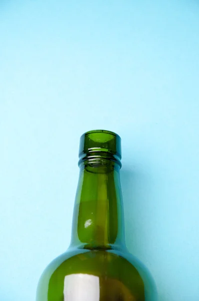 Empty wine bottle, its upper part. blue background