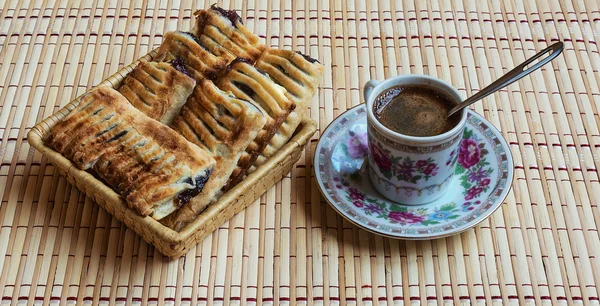 A cup of fresh black coffee and fragrant puff with berries