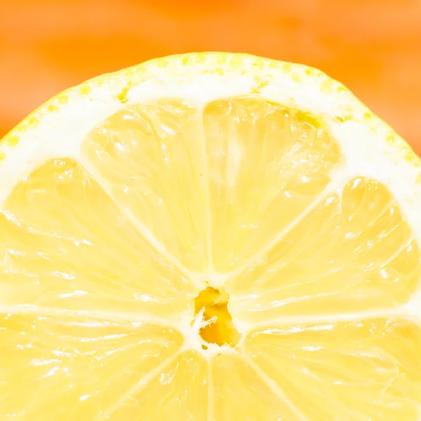 Cross section of a lemon on orange background. Square format (1:1)