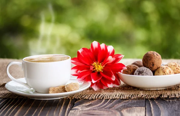 Cup of coffee, flowers and sweets shekoladnye
