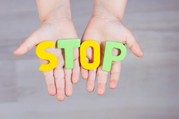 Please stop, The child asks for help. Written stop letters on the palms