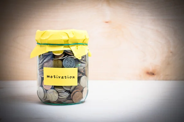 Financial concept. Coins in glass money jar with motivation label
