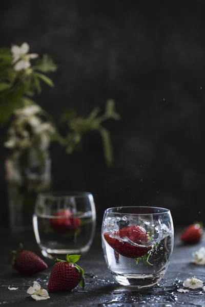 Refreshing drink with strawberries on dark background