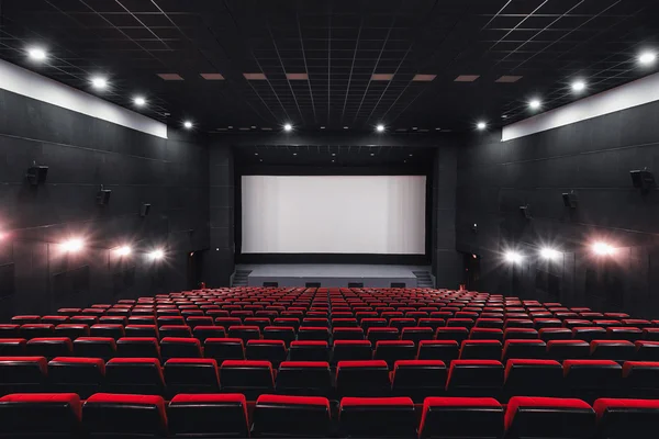 Empty rows of red theater or movie seats. Chairs in cinema hall. Comfortable armchair