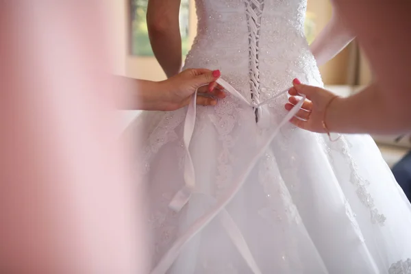 Detail of hands adjusting wedding dress lace