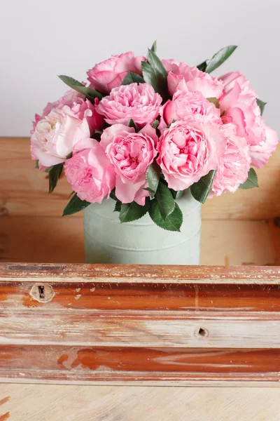 Florist did rich bunch flowers light background, wooden surface. green vase in box