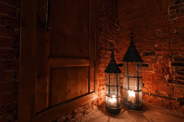Wooden door in brick room with candles. Winter Is Coming