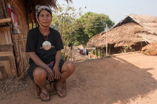 An old woman from the Akha ethnic group, rests in the shadow